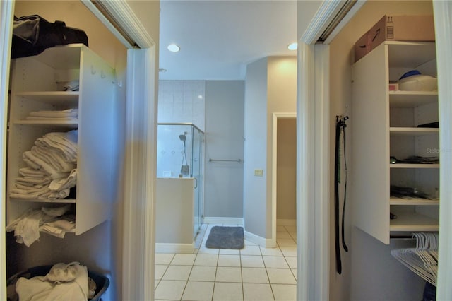 full bath featuring baseboards, recessed lighting, a stall shower, a spacious closet, and tile patterned floors