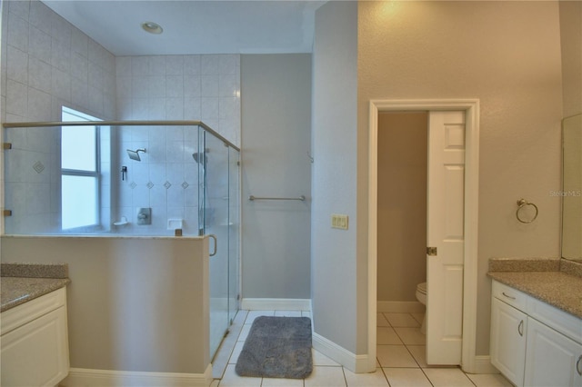 full bathroom featuring tile patterned flooring, a shower stall, and vanity