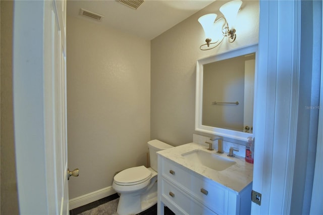 bathroom featuring visible vents, toilet, vanity, and baseboards