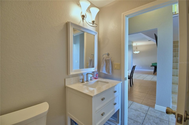 half bath featuring baseboards, toilet, a textured wall, tile patterned floors, and vanity