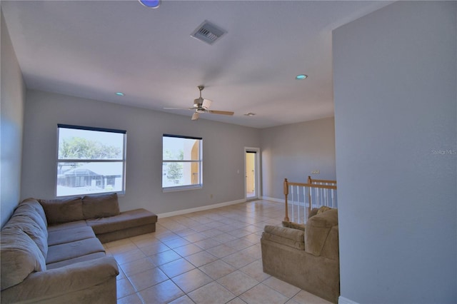 living room featuring ceiling fan, visible vents, baseboards, and light tile patterned flooring