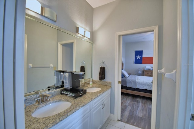 ensuite bathroom with double vanity, tile patterned floors, ensuite bathroom, and a sink