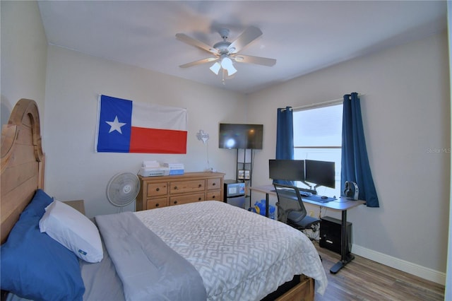 bedroom featuring a ceiling fan, wood finished floors, and baseboards