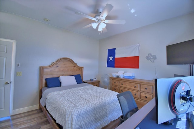 bedroom featuring wood finished floors, baseboards, and ceiling fan