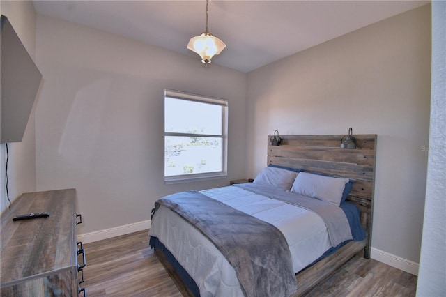 bedroom featuring wood finished floors and baseboards