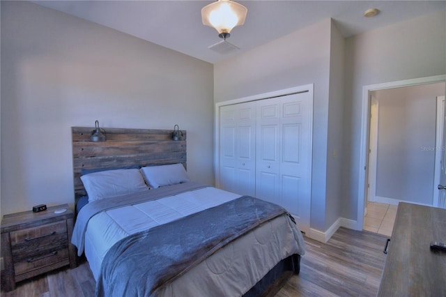 bedroom featuring a closet, baseboards, and wood finished floors