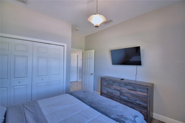 bedroom with baseboards, visible vents, and a closet