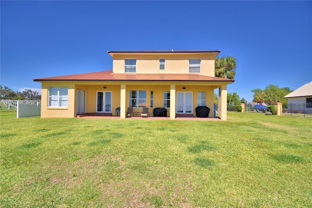 back of property with fence, stucco siding, french doors, metal roof, and a lawn