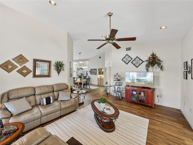 living room with dark hardwood / wood-style flooring, ceiling fan, high vaulted ceiling, and a textured ceiling