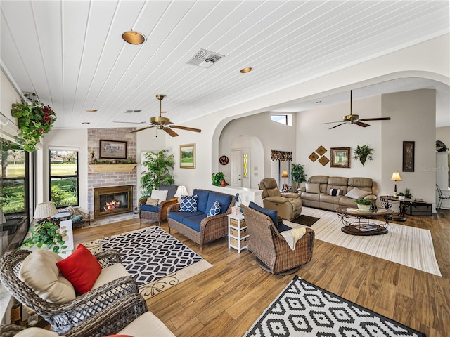 living room with hardwood / wood-style flooring, a fireplace, wooden ceiling, and ceiling fan