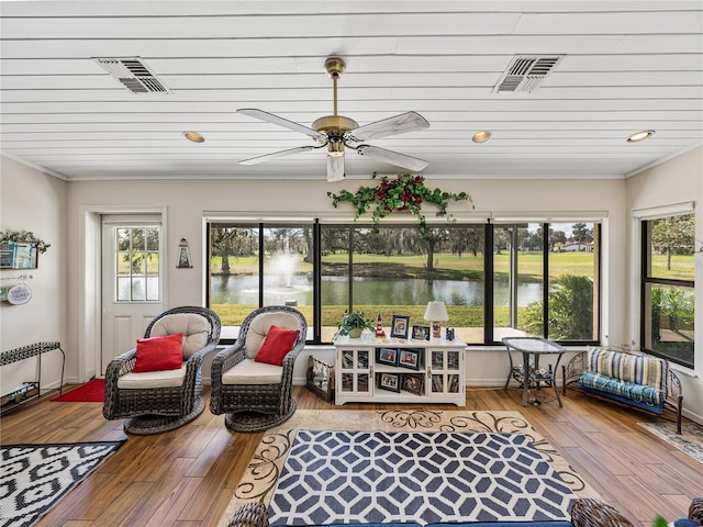 sunroom with a water view and ceiling fan