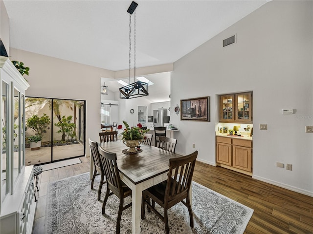 dining area featuring dark wood-type flooring and lofted ceiling