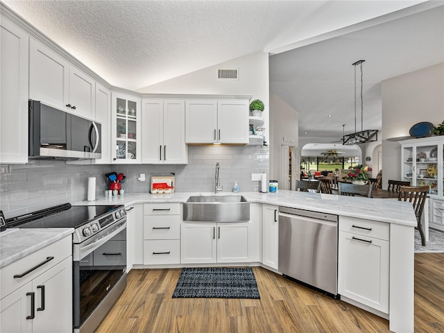 kitchen featuring white cabinetry, sink, hanging light fixtures, kitchen peninsula, and stainless steel appliances