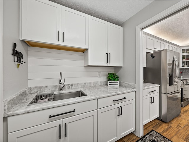 kitchen featuring sink, white cabinetry, a textured ceiling, appliances with stainless steel finishes, and dark hardwood / wood-style floors