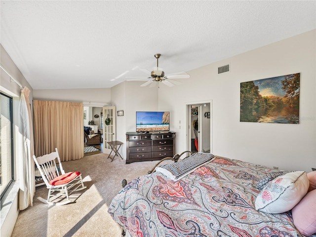 carpeted bedroom featuring ceiling fan, lofted ceiling, and a textured ceiling