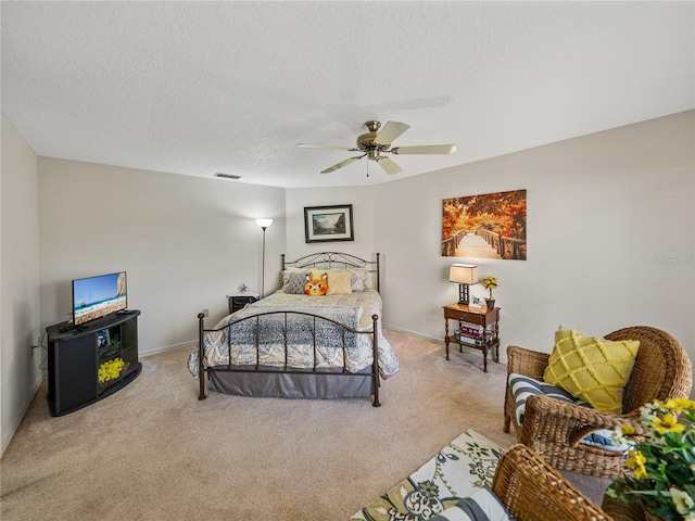 carpeted bedroom with ceiling fan and a textured ceiling