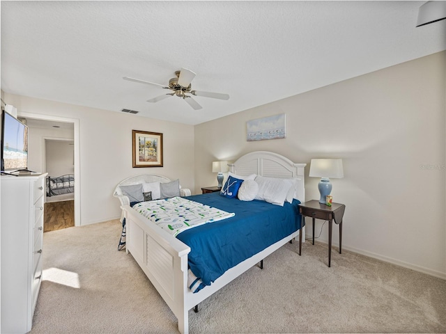 carpeted bedroom with a textured ceiling and ceiling fan