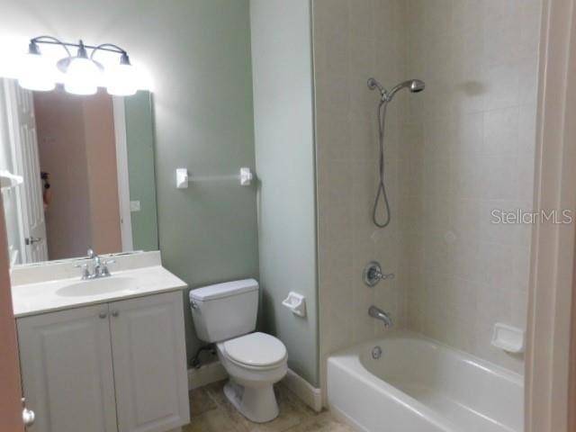 full bathroom featuring tiled shower / bath combo, vanity, tile patterned floors, and toilet