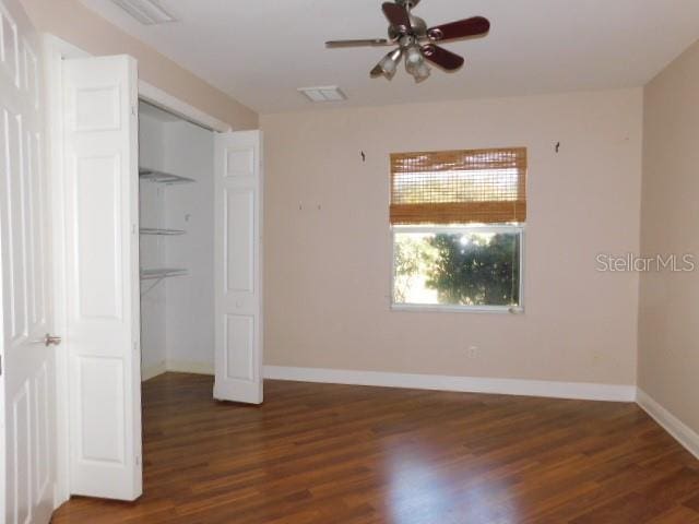 unfurnished bedroom with dark hardwood / wood-style flooring and a closet