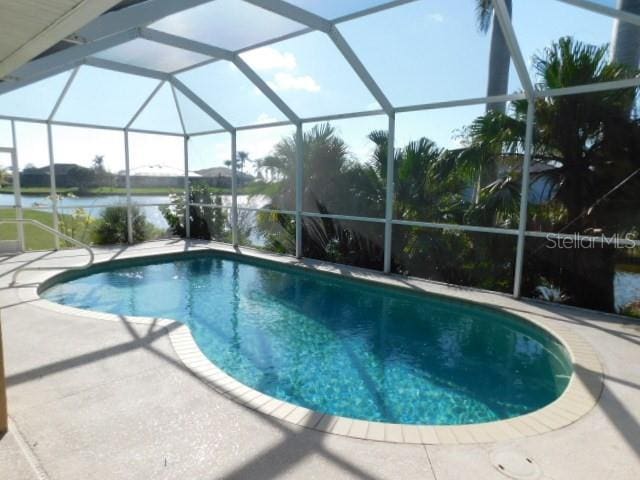 view of pool featuring a lanai, a patio, and a water view