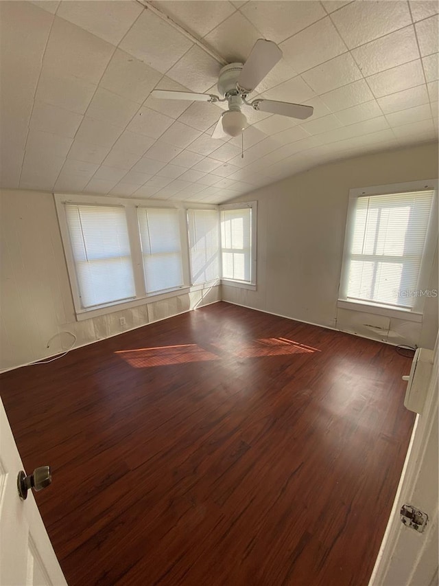 spare room with dark hardwood / wood-style flooring, vaulted ceiling, and ceiling fan