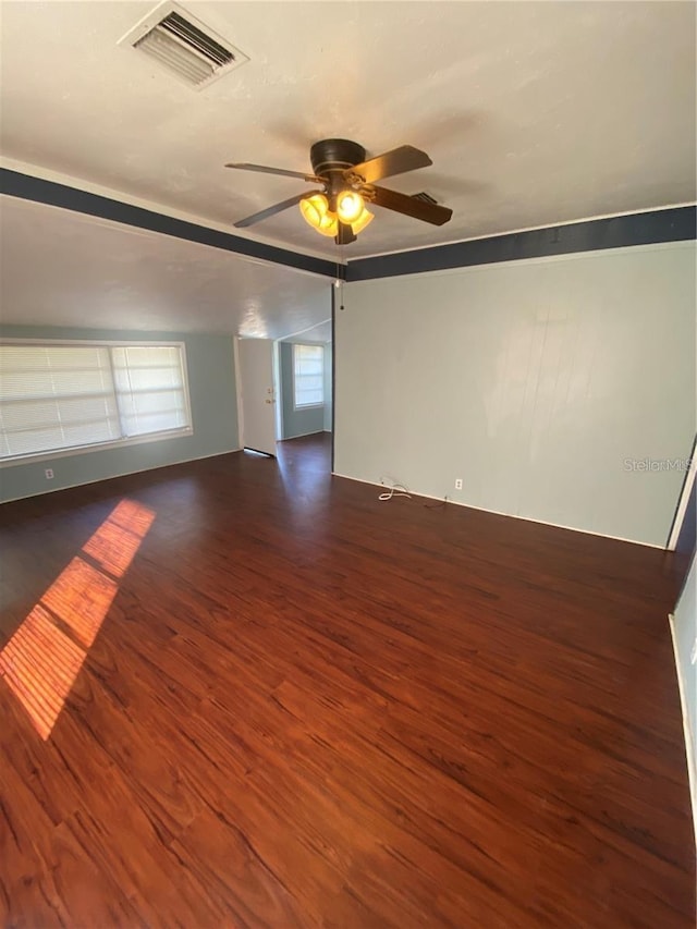 unfurnished room with ceiling fan, lofted ceiling, and dark hardwood / wood-style flooring