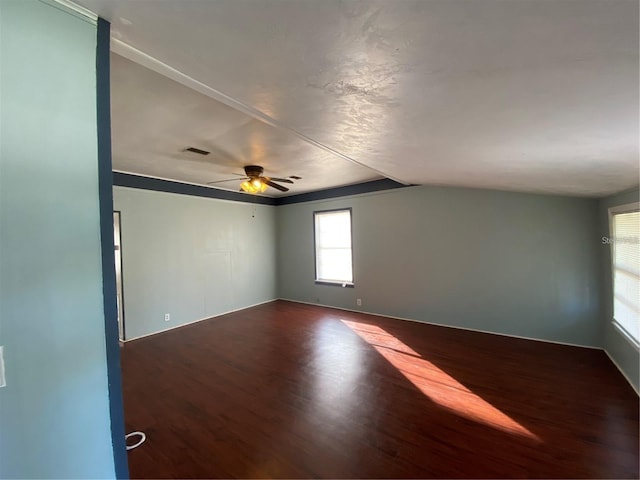 spare room with lofted ceiling, dark wood-type flooring, and ceiling fan