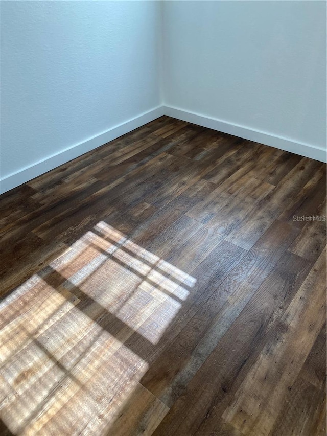 unfurnished room with dark wood-type flooring