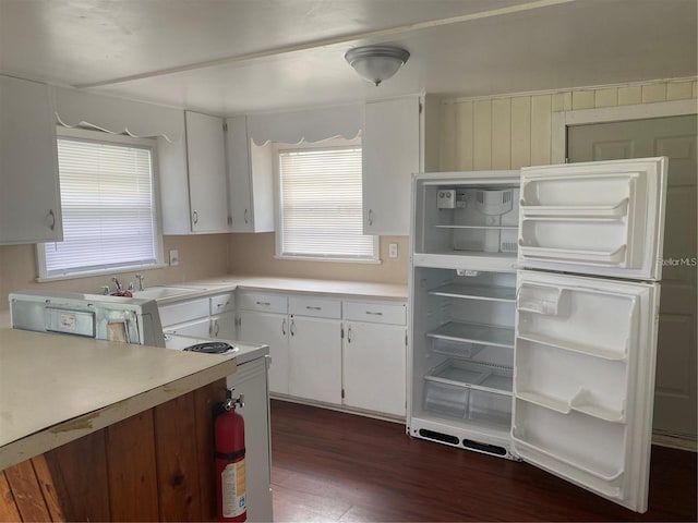 kitchen with white cabinetry, fridge, sink, and dark wood-type flooring