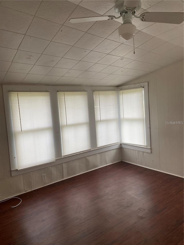 unfurnished room featuring ceiling fan, dark hardwood / wood-style floors, and vaulted ceiling