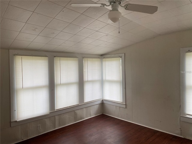 empty room with vaulted ceiling, ceiling fan, and dark hardwood / wood-style flooring