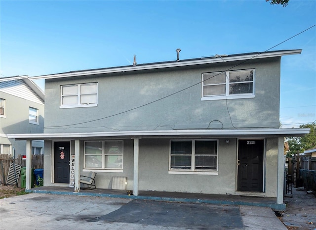 view of front of property with stucco siding and fence