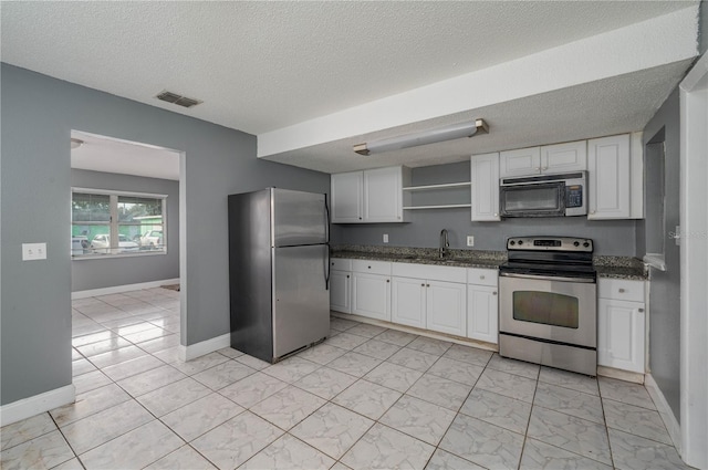 kitchen with visible vents, open shelves, a sink, stainless steel appliances, and white cabinetry