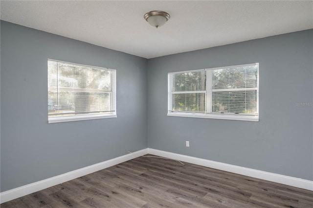 unfurnished room with dark wood-type flooring