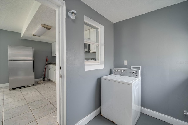 washroom with baseboards, washer / dryer, laundry area, a textured ceiling, and marble finish floor