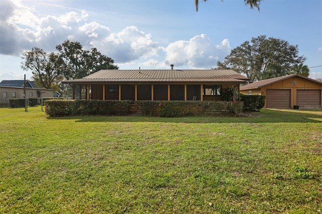 rear view of house with an outbuilding, a garage, and a yard