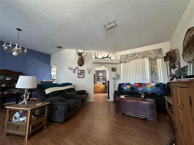 living room with a textured ceiling, dark hardwood / wood-style floors, and an inviting chandelier