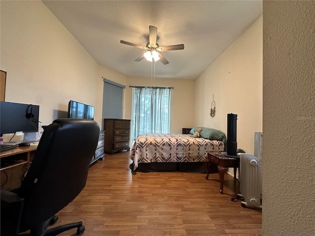 bedroom featuring radiator heating unit, ceiling fan, and hardwood / wood-style floors