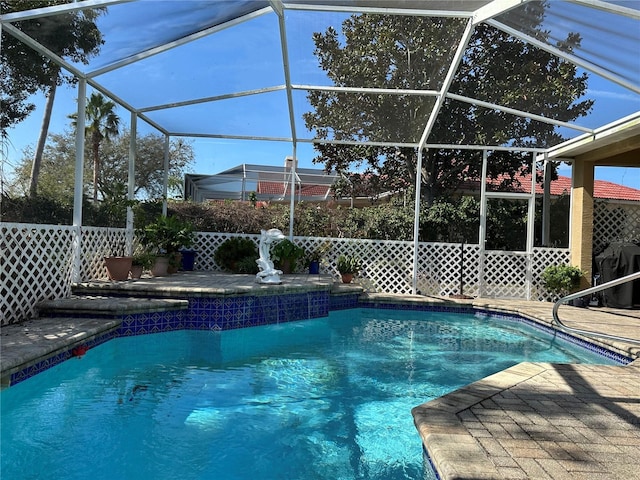 view of swimming pool with pool water feature, a patio, glass enclosure, and area for grilling