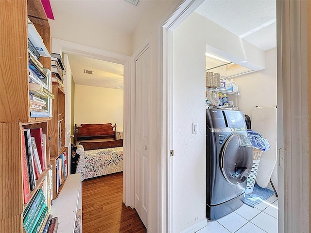 clothes washing area with wood finished floors, visible vents, washer / dryer, and laundry area