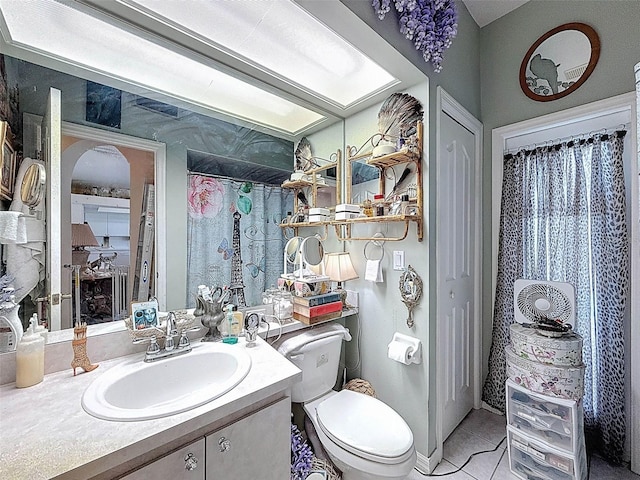 full bathroom with toilet, tile patterned flooring, and vanity