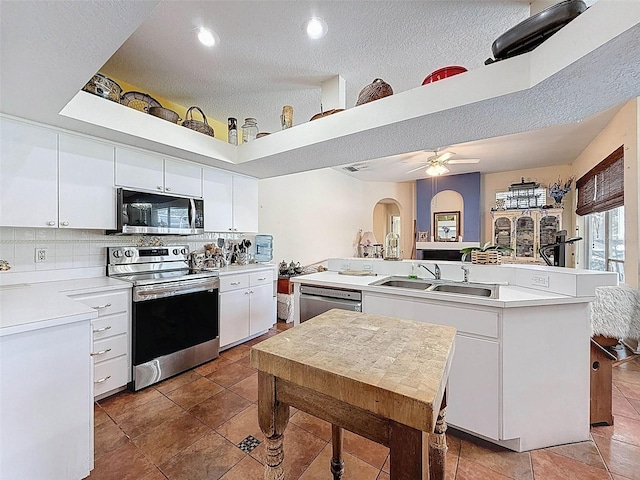 kitchen with appliances with stainless steel finishes, light countertops, and white cabinets