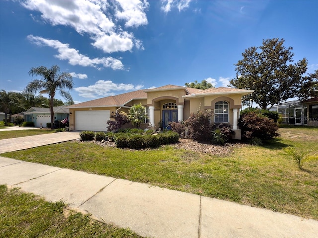 view of front facade featuring a front yard, stucco siding, decorative driveway, and an attached garage