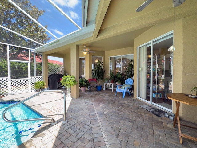 view of patio / terrace featuring a ceiling fan, an outdoor pool, and glass enclosure