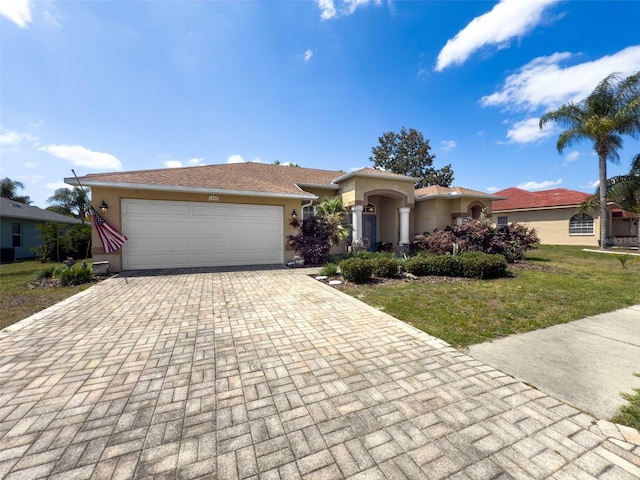 ranch-style home with an attached garage, a front yard, decorative driveway, and stucco siding