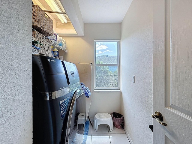 laundry area featuring tile patterned floors, laundry area, and baseboards