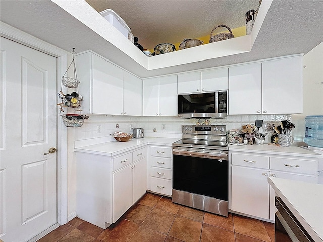 kitchen with white cabinetry, backsplash, light countertops, a textured ceiling, and appliances with stainless steel finishes