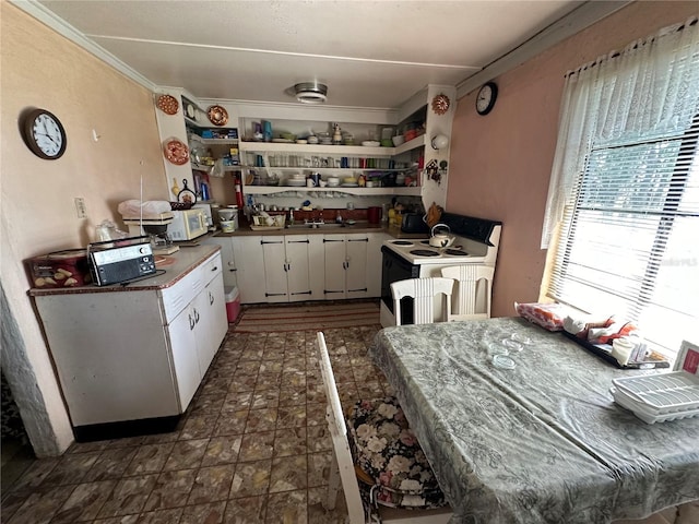 kitchen with crown molding, white cabinets, and white electric stove