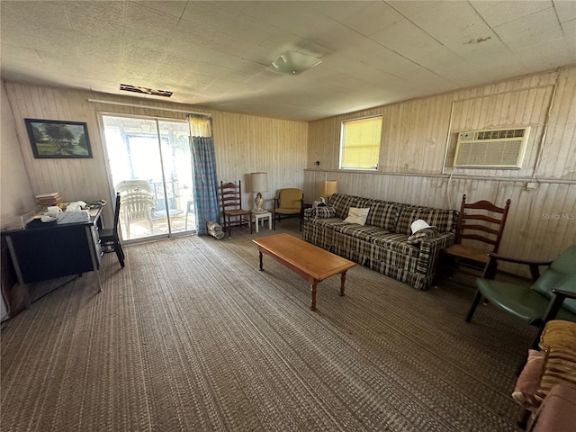 sitting room with carpet floors, an AC wall unit, and wooden walls