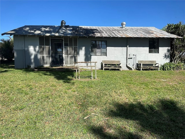 rear view of property featuring a yard and stucco siding